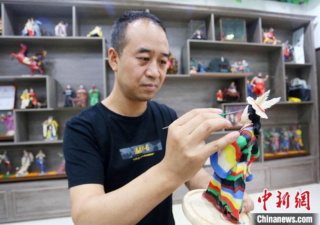 圖為安秋平正在創(chuàng)作代表隴南文縣民俗的《白馬人》作品?！「哒?攝