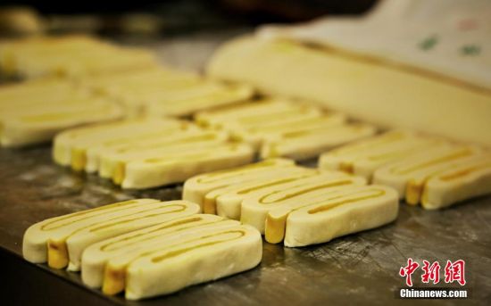 圖為面劑被涂上胡麻油，切成條狀用作月餅的花型制作。張文 攝