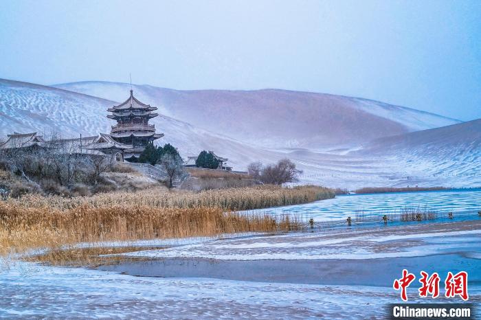 2021年11月28日，雪落鳴沙山月牙泉景區(qū)?！⊥醣筱y 攝