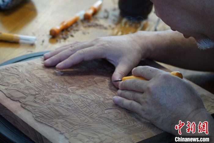 圖為徐晉林湊近木板，近距離制作雕版畫。　九美旦增 　攝