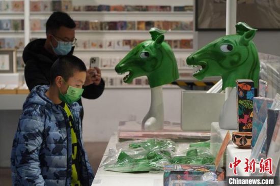 圖為“神馬來(lái)了”銅奔馬頭套吸引參觀(guān)者駐足。　九美旦增 攝