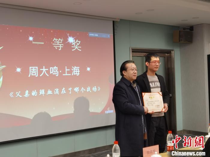 圖為作家、西北師范大學新聞與傳媒學院院長徐兆壽頒發(fā)一等獎證書，代領獎者上臺領獎?！钅?攝