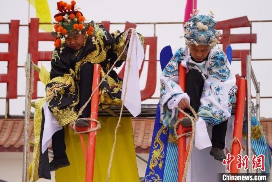 圖為“苦水高高蹺”表演者通過麻繩將腳固定在腳踏板，并在腿部纏繞六七圈?！【琶赖┰?攝