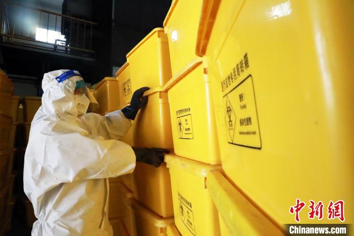圖為工作人員搬運醫(yī)療廢物專用周轉(zhuǎn)箱?！∥航ㄜ?攝