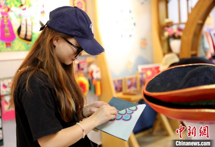 圖為民眾體驗(yàn)國家級(jí)非遺項(xiàng)目盤繡技藝?！⊙Φ?攝