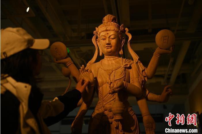 圖為季茂杰觀察自己創(chuàng)作的敦煌木雕。李亞龍 攝</p>
<p>