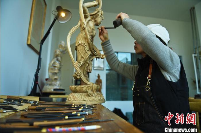 圖為季茂杰進行敦煌元素的木雕創(chuàng)作。李亞龍 攝</p>
<p>