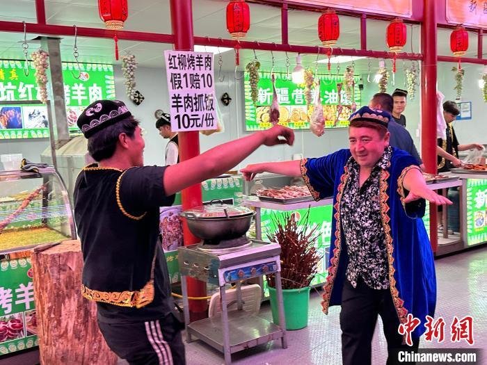 圖為餐飲經(jīng)營者在“西涼不夜城”跳起舞蹈引客?！〈魑牟?攝</p><p>