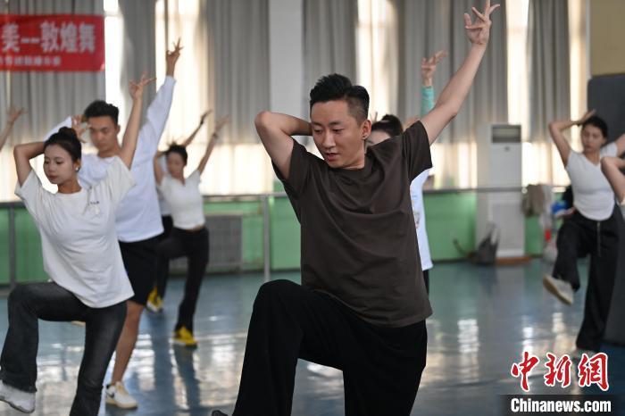 6月6日，在甘肅敦煌青年夜校課程中，青年學(xué)員學(xué)習(xí)敦煌舞課程。李亞龍 攝　　