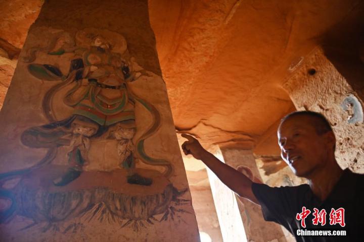 7月15日，甘肅省平?jīng)鍪袥艽h百里石窟長廊羅漢洞石窟內(nèi)，該窟文保員郭建平介紹窟內(nèi)石刻彩繪壁畫。郭建平家中三代人曾自發(fā)保護(hù)羅漢洞石窟。羅漢洞石窟遺存40余個窟龕，以北魏至清代風(fēng)格為主。中新社記者 李亞龍 攝</p>
<p>