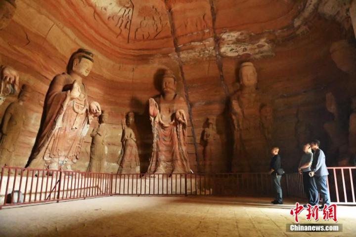 7月15日，游人參觀甘肅省平?jīng)鍪袥艽h百里石窟長廊中的南石窟寺1號窟。百里石窟長廊位于涇川縣境內(nèi)，由512個石窟、5眼窟中石井組成，現(xiàn)存王母宮石窟、鳳凰山石窟、南石窟寺、丈八寺石窟、羅漢洞石窟、太山寺石窟等規(guī)模較大的石窟群，還有數(shù)量眾多的小石窟群。南石窟寺開鑿于北魏永平三年，其中1號窟屬于大型七佛窟，七佛高達(dá)6米。中新社記者 李亞龍 攝