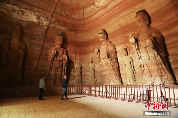 7月15日，游人參觀甘肅省平?jīng)鍪袥艽h百里石窟長廊中的南石窟寺1號窟。百里石窟長廊位于涇川縣境內(nèi)，由512個石窟、5眼窟中石井組成，現(xiàn)存王母宮石窟、鳳凰山石窟、南石窟寺、丈八寺石窟、羅漢洞石窟、太山寺石窟等規(guī)模較大的石窟群，還有數(shù)量眾多的小石窟群。南石窟寺開鑿于北魏永平三年，其中1號窟屬于大型七佛窟，七佛高達(dá)6米。中新社記者 李亞龍 攝