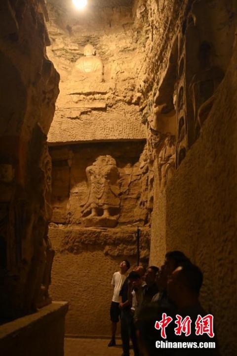 7月15日，游人參觀甘肅省平?jīng)鍪袥艽h百里石窟長廊中的王母宮石窟。百里石窟長廊位于涇川縣境內(nèi)，由512個石窟、5眼窟中石井組成，現(xiàn)存王母宮石窟、鳳凰山石窟、南石窟寺、丈八寺石窟、羅漢洞石窟、太山寺石窟等規(guī)模較大的石窟群，還有數(shù)量眾多的小石窟群。王母宮石窟又名千佛洞，該窟設(shè)計宏大，造像生動，窟內(nèi)擁有造像數(shù)百尊，是較為珍貴的佛教文化遺存。中新社記者 李亞龍 攝</p>
<p>