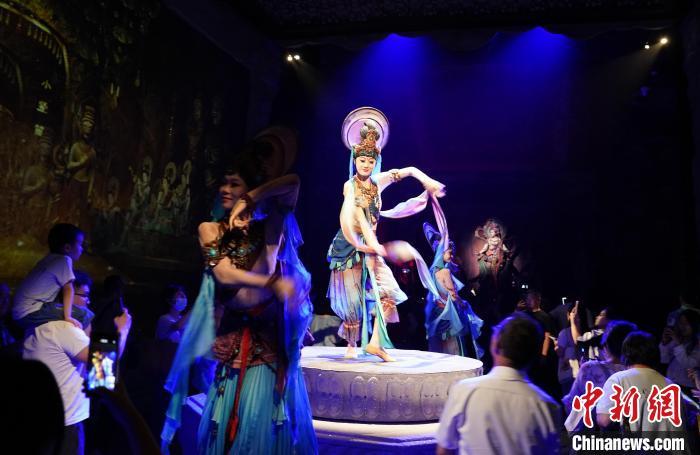 《樂動(dòng)敦煌》是全球首部洞窟式沉浸體驗(yàn)劇，利用真人與數(shù)字影像虛實(shí)交換實(shí)現(xiàn)沉浸式體驗(yàn)。圖為2023年8月28日晚，《樂動(dòng)敦煌》演出。(資料圖)中新社記者 毛建軍 攝