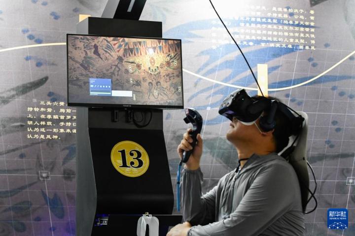 7月22日，游客借助VR設(shè)備沉浸式游覽莫高窟第285窟虛擬場景。新華社記者 郎兵兵 攝